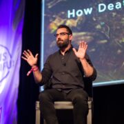 DS Moss sitting on a stage speaking