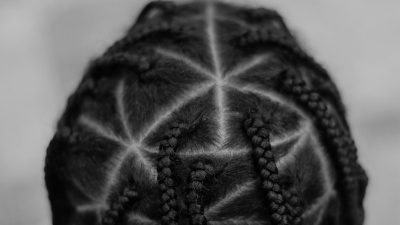 https://unsplash.com/photos/ptyj_QoPRsQ [ID: A close-up photograph of the back of a persons head, gives us a look into the triangular box braids that cover their scalp. The picture is in black and white.]