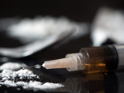 Close up of drug syringe and cooked heroin